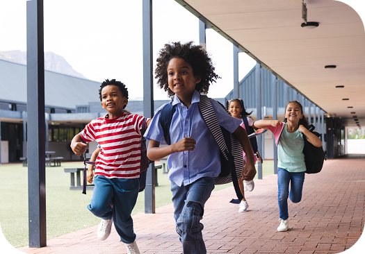 Alunos da Amplia Plataforma de Ensino correndo e sorrindo no pátio da escola, simbolizando alegria e entusiasmo pelo aprendizado.