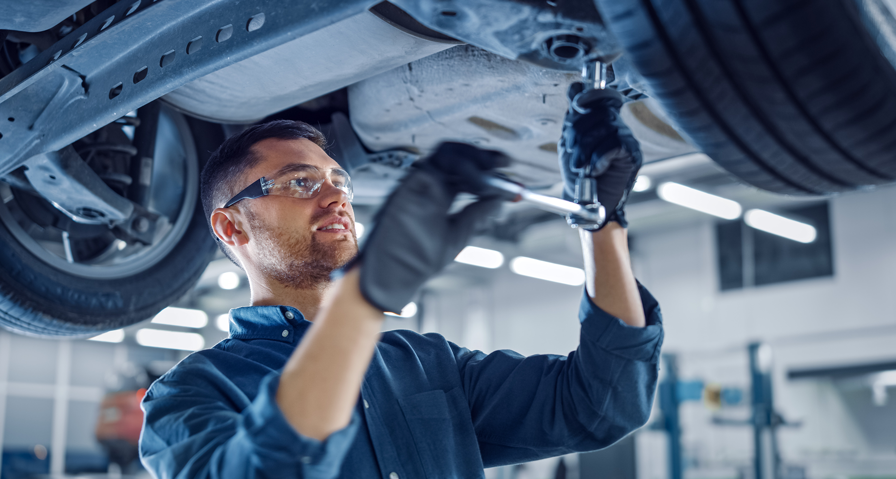 Mecânico inspecionando pneu de carro em oficina