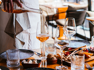 Taças de vinho à mesa compondo experiência gastronômica com curadoria e sofisticação.