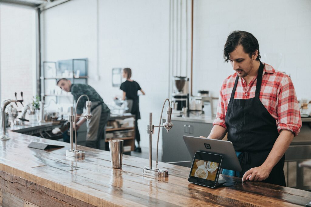 Funcionário usando tablet para gerenciar pedidos em cafeteria