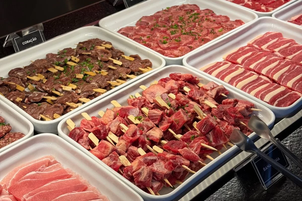 Exposição de carnes cruas organizadas em bandejas, incluindo cortes variados e espetinhos do churrasco coreano do restaurante Taisho em Curitiba.